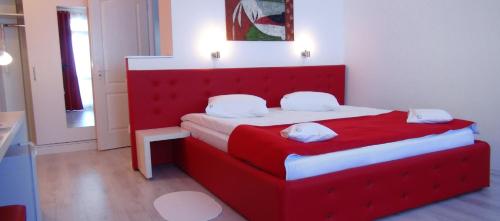 a red bed with a red headboard in a room at Casa OK by OVO in Vama Veche