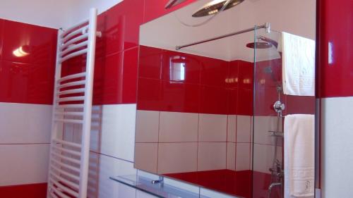 a red and white bathroom with a shower and a mirror at Casa OK by OVO in Vama Veche