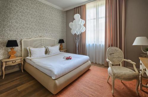 a hotel room with a bed and a chair and balloons at Midalidare Hotel & Spa in Mogilovo
