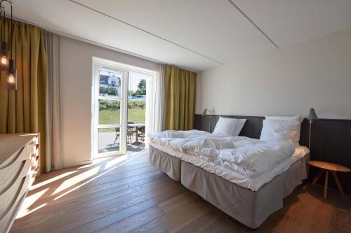 a hotel room with a bed and a large window at Nordlandet in Allinge