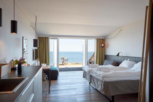 a hotel room with a bed and a view of the ocean at Nordlandet in Allinge