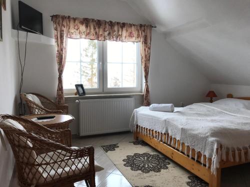 um quarto com uma cama e uma janela em Pokoje Agroturystyka Koczy Zamek em Koniaków