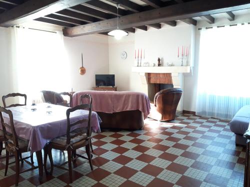 une salle à manger avec une table et une cheminée dans l'établissement Gîte de La Sapinière à 15 min du Puy du Fou, à La Pommeraie-sur-Sèvre