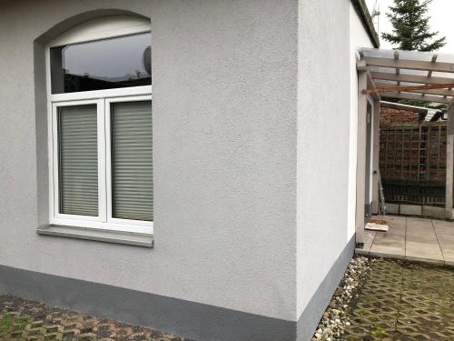 a white house with a window and a patio at Ferienwohnung A.Engelhardt in Nordhausen