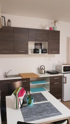 a kitchen with brown cabinets and a table in a kitchen at Apartmány Tylovice in Rožnov pod Radhoštěm