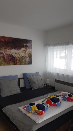 a bedroom with a large bed with a painting on the wall at Apartmány Tylovice in Rožnov pod Radhoštěm