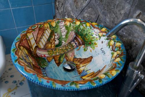 a bucket with a painting on it in a bathroom at La Dimora le Fumarole Rooms in Ercolano