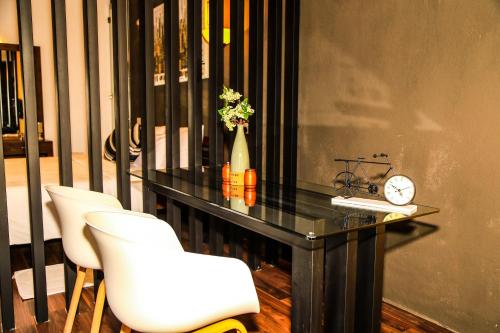 a black table with two white chairs and a clock at Eden Studio Apartments - 1 in Colombo