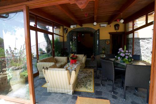 a screened in porch with a table and chairs at La Dimora le Fumarole Rooms in Ercolano
