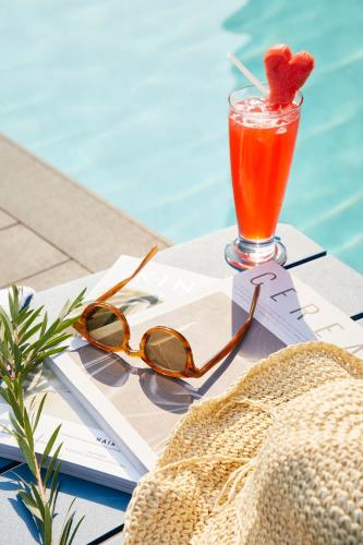 a drink sitting on a table next to a pool at The Quarter Ladprao by UHG in Bangkok