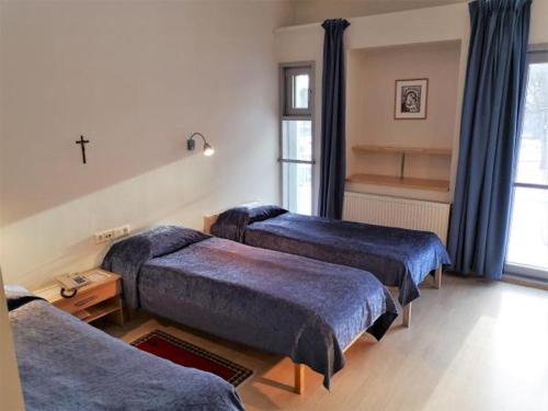 a room with three beds with blue covers in it at Pirita Klooster in Tallinn