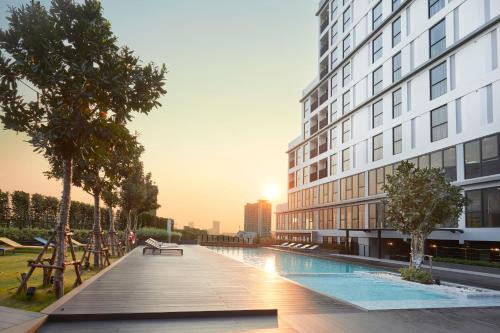 a building with a swimming pool next to a building at The Quarter Ladprao by UHG in Bangkok