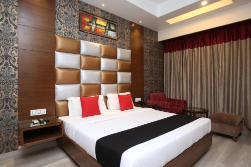 钱德加尔Hotel Shagun Chandigarh Zirakpur的一间带床和椅子的酒店房间