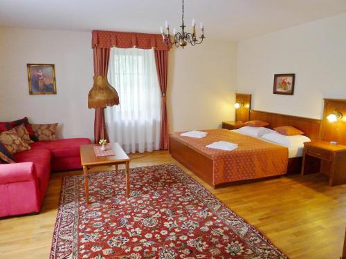 プラハにあるホテル ノサルのベッドとソファ付きのホテルルーム