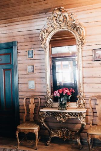 a mirror sitting on a table with a vase of roses at Tuddal Høyfjellshotel in Tuddal