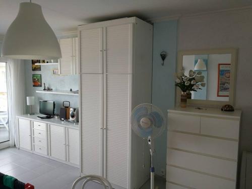 una cocina con una habitación con ventilador y nevera en L´Estartit, estudio en primera linea de mar., en L'Estartit