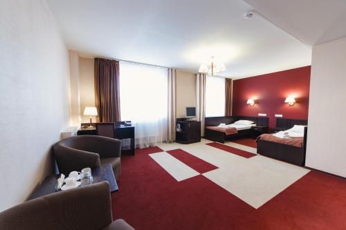 pokój hotelowy z 2 łóżkami i salonem w obiekcie Deryabin Hotel w mieście Iżewsk