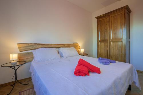a bedroom with a white bed with red towels on it at Villa Giulia in Lucignano