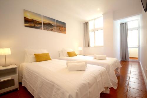 波爾蒂芒的住宿－T1 Varandas da Rocha by amcf，白色客房的两张床,设有两扇窗户