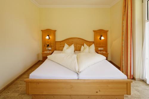 a bedroom with a large bed with white sheets and pillows at Appartment Kinigadner in Pertisau