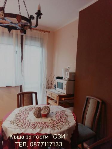 a kitchen with a table and chairs and a microwave at Къща за гости Ози in Ovchartsi