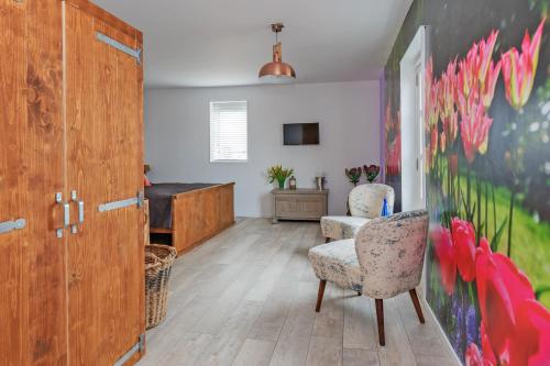 a living room with two chairs and a desk at Wellness Bed & Breakfast Pergamo in Voorhout