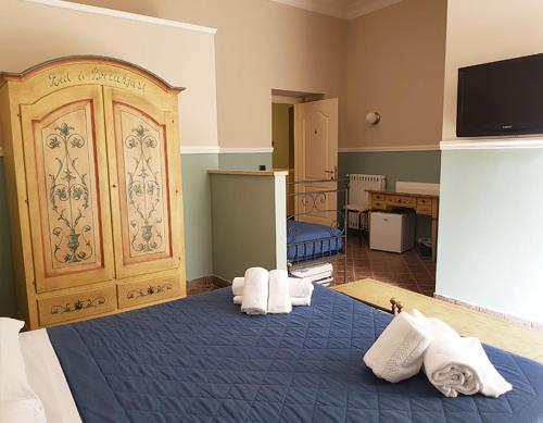 Un dormitorio con una cama azul con toallas. en B&B Delle Palme, en Nápoles