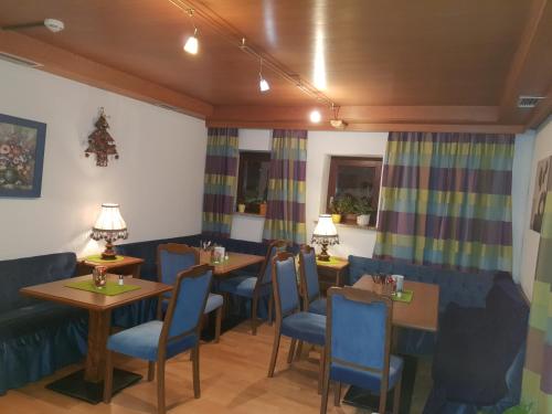 a dining room with tables and blue chairs at Sportpension Christina by PiaundDirk in Fügen
