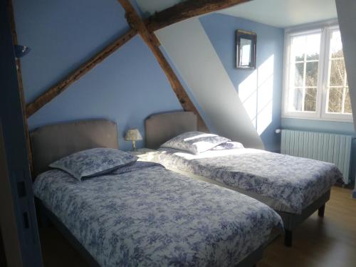 2 camas en una habitación con paredes y ventanas azules en La Maison du Closier, en Blois