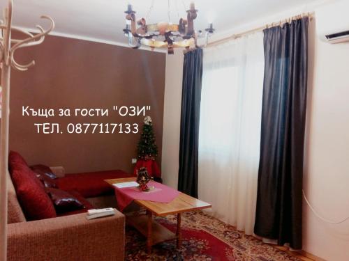 a living room with a couch and a table at Къща за гости Ози in Ovchartsi
