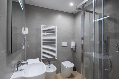 a bathroom with a toilet and a sink and a shower at Hotel Excelsior Pavia in Pavia