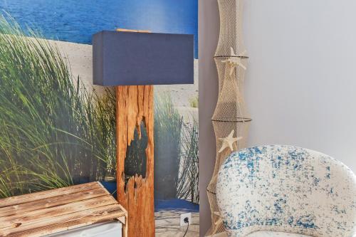 a room with a chair and a lamp at Wellness Bed & Breakfast Pergamo in Voorhout