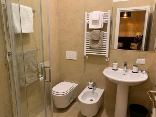 a bathroom with a toilet and a sink and a shower at FiumicinoA57 in Fiumicino
