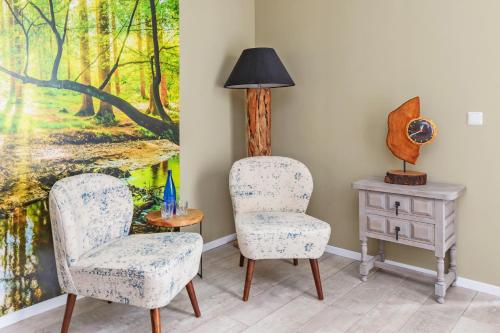 a room with two chairs and a table with a painting at Wellness Bed & Breakfast Pergamo in Voorhout