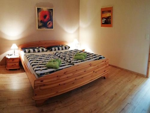 ein Schlafzimmer mit einem großen Holzbett mit zwei Fröschen darauf in der Unterkunft Ferienwohnung Christian in Bad Birnbach