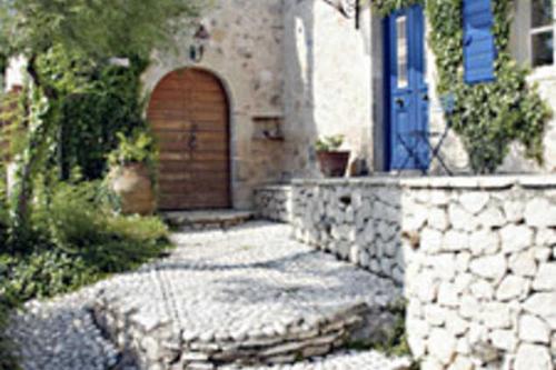 una casa con una porta in legno e un muro in pietra di Pavezzo Country Retreat a Katouna