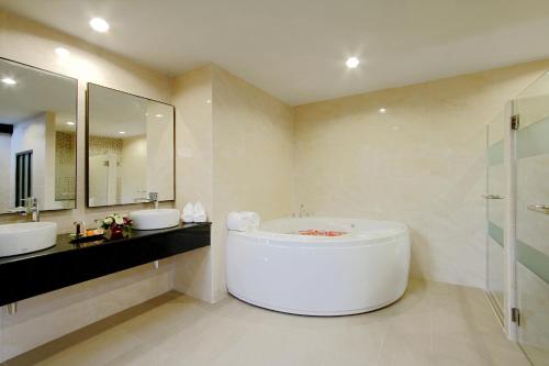 a large bathroom with two sinks and a tub at Kata Sea Breeze Resort - SHA Plus in Kata Beach