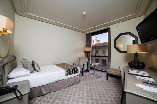 a hotel room with a bed and a mirror at Hotel Bahía in Santander