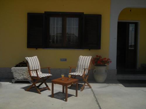 due sedie e un tavolo di fronte a un edificio di La Dolce Sosta a Pietrelcina