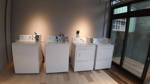 four washing machines are lined up in a room at MR. NORDIC INN in Hualien City