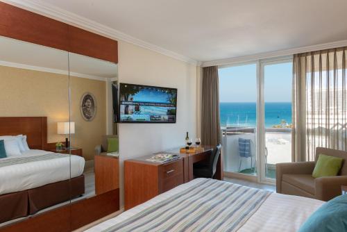 a hotel room with a bed and a view of the ocean at Herods Tel Aviv By The Beach in Tel Aviv