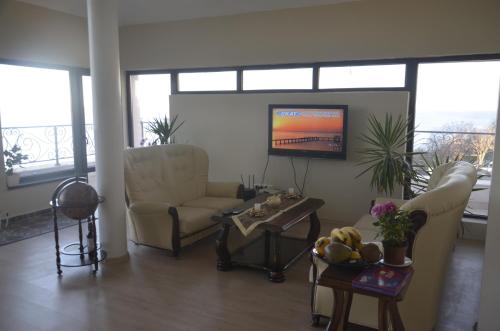 a living room with a couch and a tv at Ashram Hotel in Primorsko