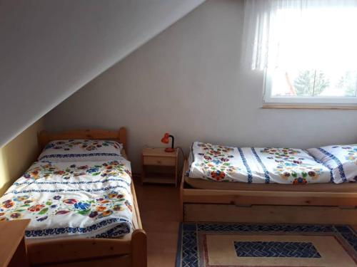a bedroom with two beds and a window at Chata Ľubka in Vyšné Ružbachy