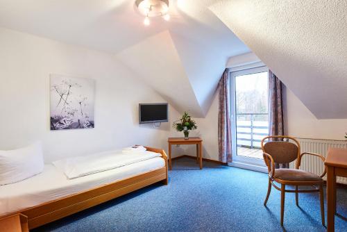 Habitación de hotel con cama y ventana en Krelinger Freizeit- und Tagungszentrum, en Walsrode