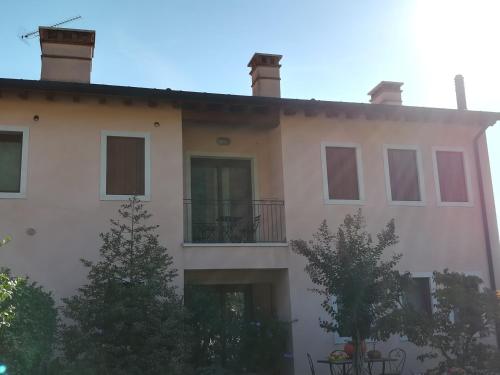 a large white building with a balcony and trees at Casa Felicité - di Francesca e Antonio in Valmareno