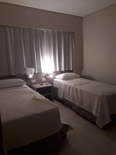 a hotel room with two beds and a window at SALINAS PARK RESORT in Salinópolis