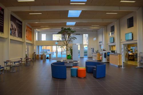 a lobby with chairs and tables in a building at Danhostel Nørresundby Skansen in Nørresundby