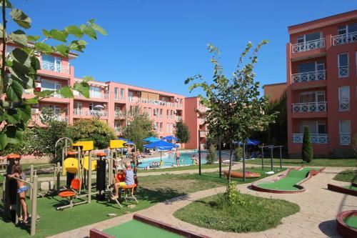 un parque infantil frente a un edificio con piscina en Sunny Day 6 - Menada Apartments, en Sunny Beach