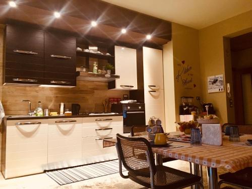 uma cozinha com uma mesa com cadeiras e uma mesa e uma cozinha com preto em B&B AMICI MIEI em Lanciano
