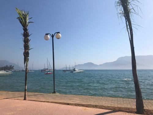 a street light next to a body of water with boats at Duplex Ilhabela Pereque in Ilhabela